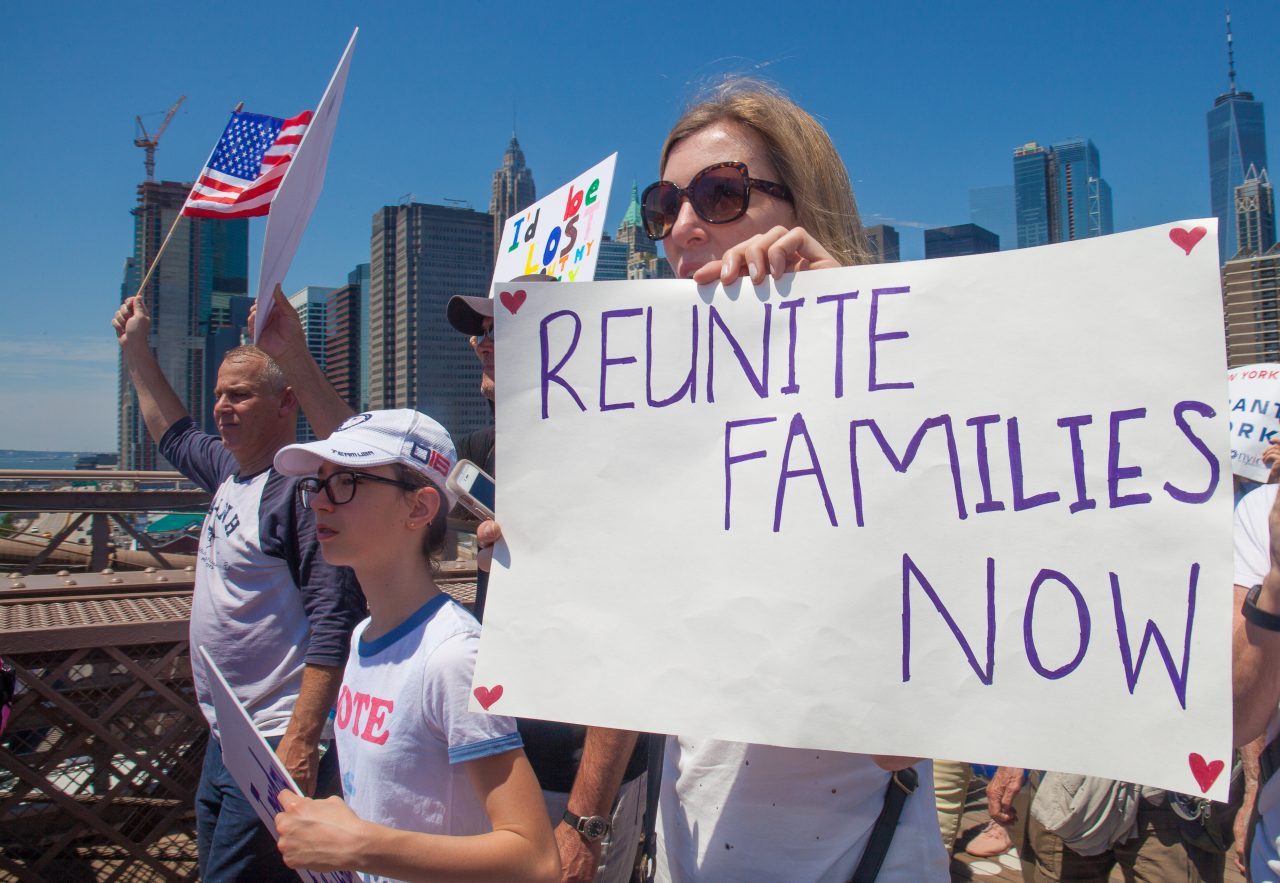 6/30/2018. New York City - March: “Families Belong Together.” Woman with a sign that reads: "Reunite families now." People crossing the Brooklyn Bridge in support of refugee families. People’s protectors are marching from Foley Square in Manhattan to Cadman Plaza in Brooklyn. Credit: Photo by Javier Soriano/LoveIsAmor.com