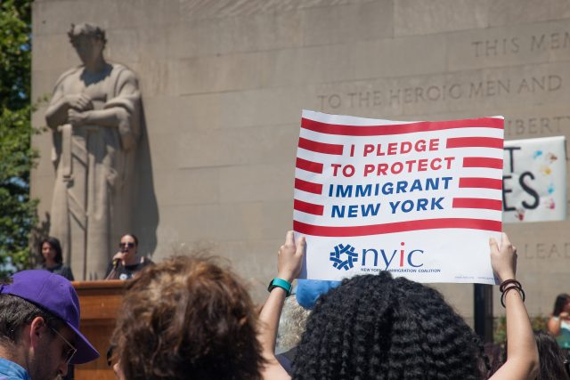 6/30/2018. New York City - March: “Families Belong Together.” Woman with a sign that reads: "I pledge to protect immigrant New York. NYIC/New York Immigration Coalition." People at Cadman Plaza in support of refugee families. People’s protectors marched from Foley Square in Manhattan to Cadman Plaza in Brooklyn. Photo by Javier Soriano/LoveIsAmor.com