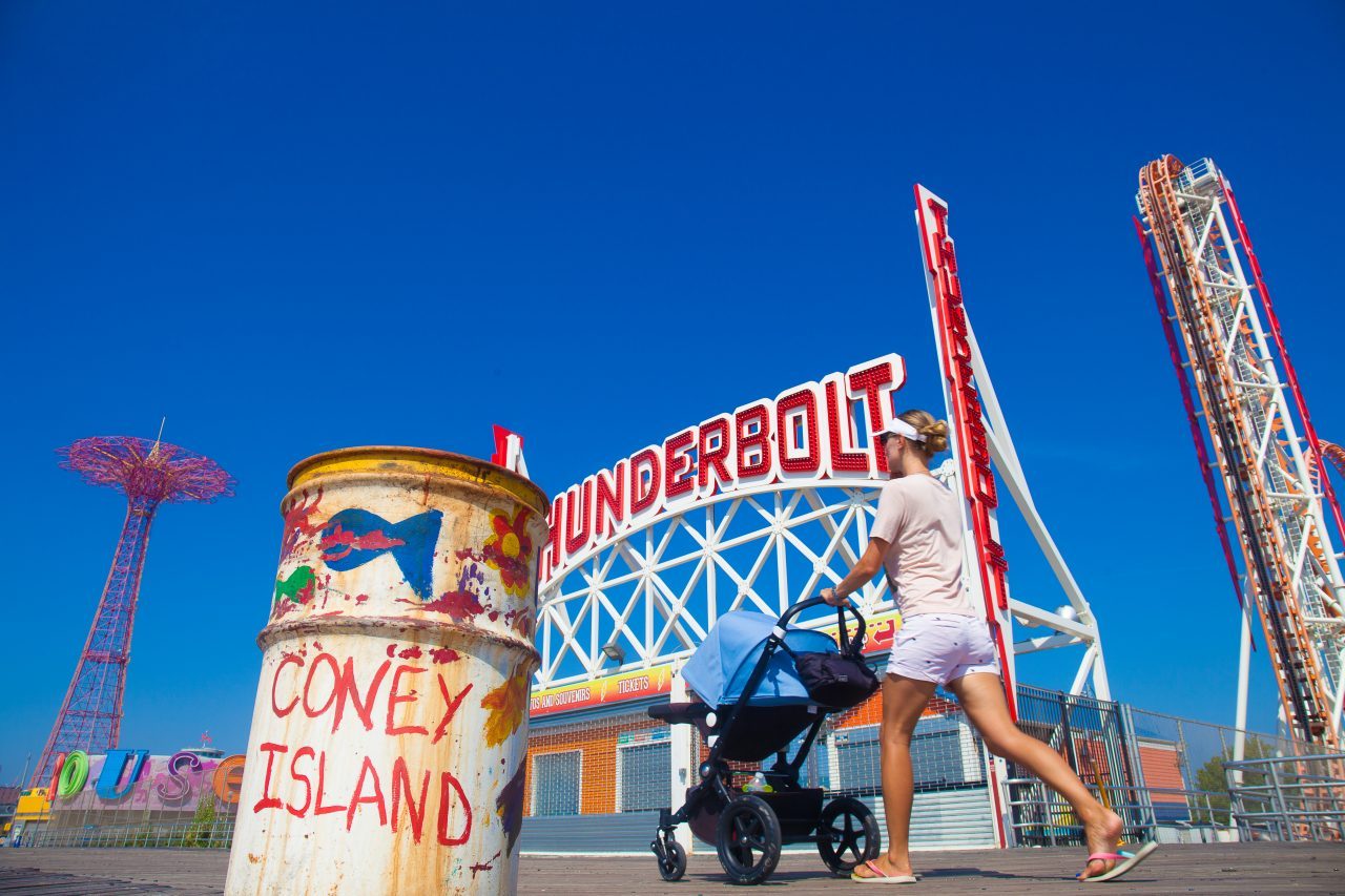 9/5/2018 Boardwalk, Parachute Jump, Thunderbolt, woman with a baby and trash can. Coney Island. Brooklyn, New York City. Credit: Photo by LoveIsAmor.com