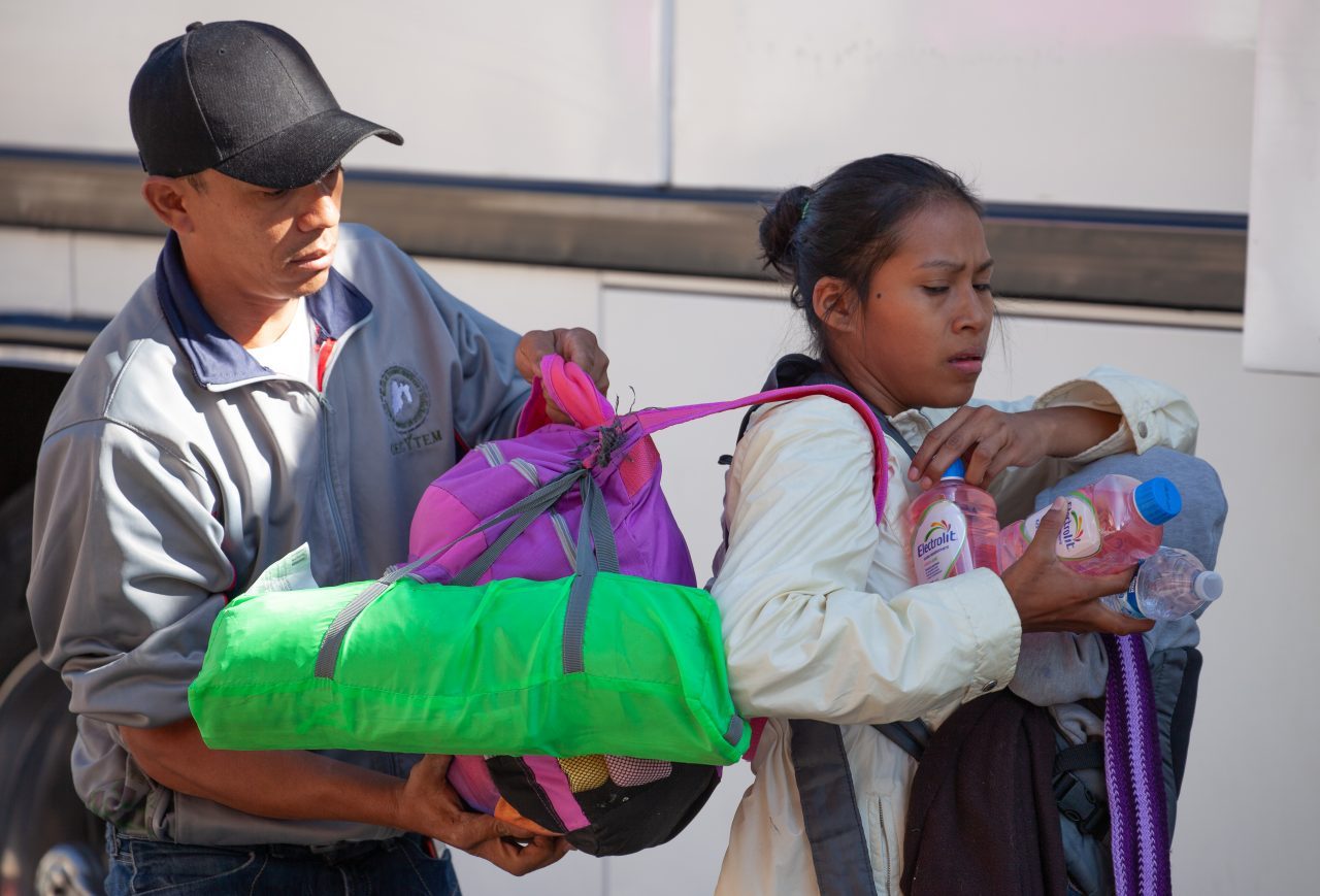 Tlaquepaque, Guadalajara. Jalisco, Mexico. Monday, November 19th, 2018. Man helping a refugee woman. This mother and her baby are boarding a bus to Sinaloa. Hundreds of refugees fleeing violence and extreme poverty in Central America have been staying at "El Refugio. Casa del Migrante" for one or two days. This immigrant family is part of the second caravan. They want to apply for asylum in the United States of America. Credit: Photo by LoveIsAmor.com
