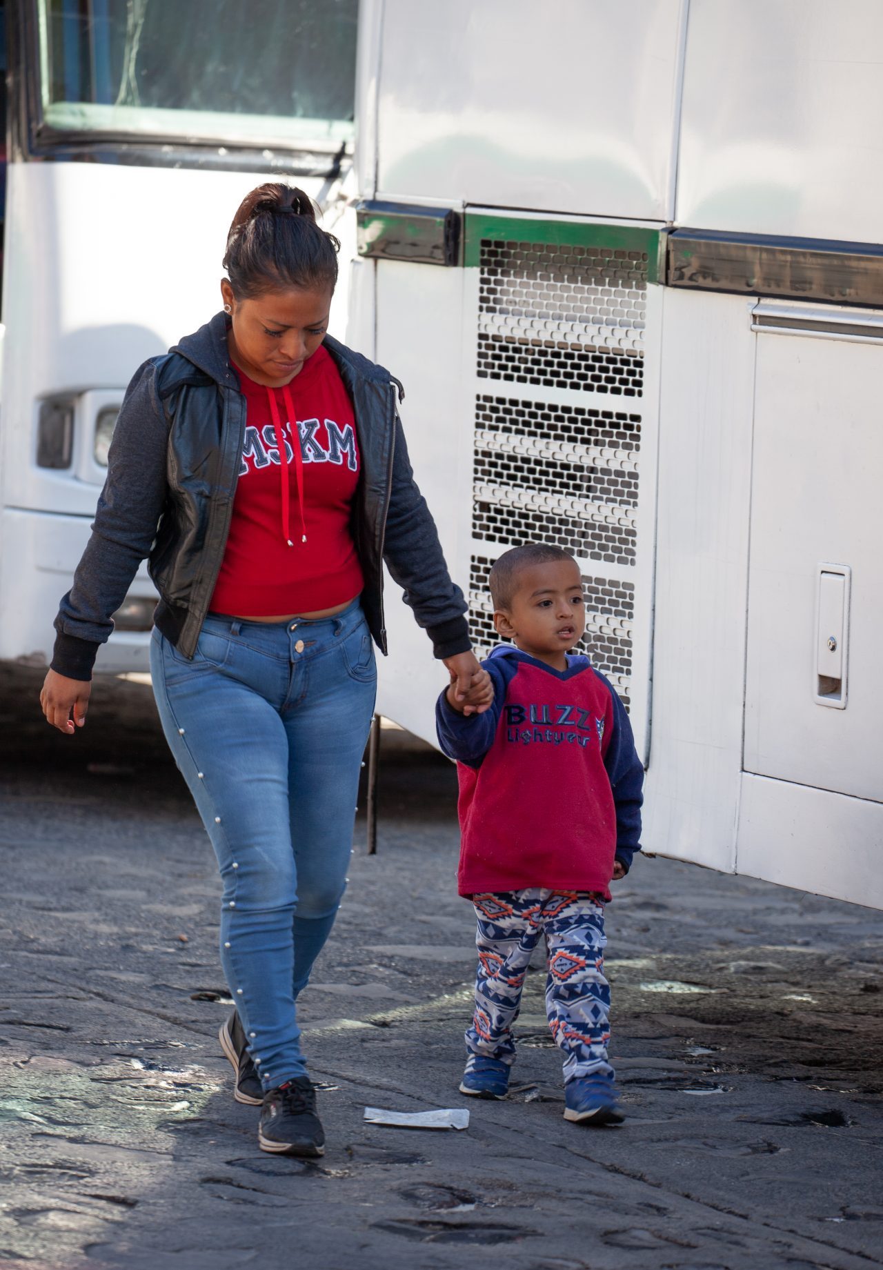 Tlaquepaque, Guadalajara. Jalisco, Mexico. Monday, November 19th, 2018. A refugee child and his mother boarding a bus to Sinaloa. Hundreds of refugees fleeing violence and extreme poverty in Central America have been staying at "El Refugio. Casa del Migrante" for one or two days. These refugees are part of the second caravan. Credit: Photo by LoveIsAmor.com