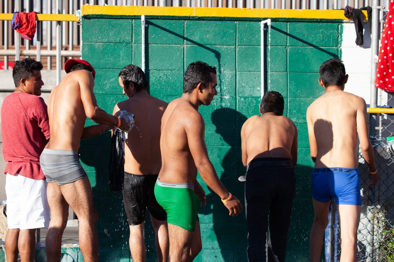 Tijuana, Baja California. Mexico. Monday, November 26th, 2018. A group of refugee men taking a shower at Unidad Deportiva Benito Juárez (an improvised shelter for the caravans of immigrants). They are fleeing violence and extreme poverty in their countries in Central America. They want to apply for asylum in the United States of America. Credit: Photo by LoveIsAmor.com