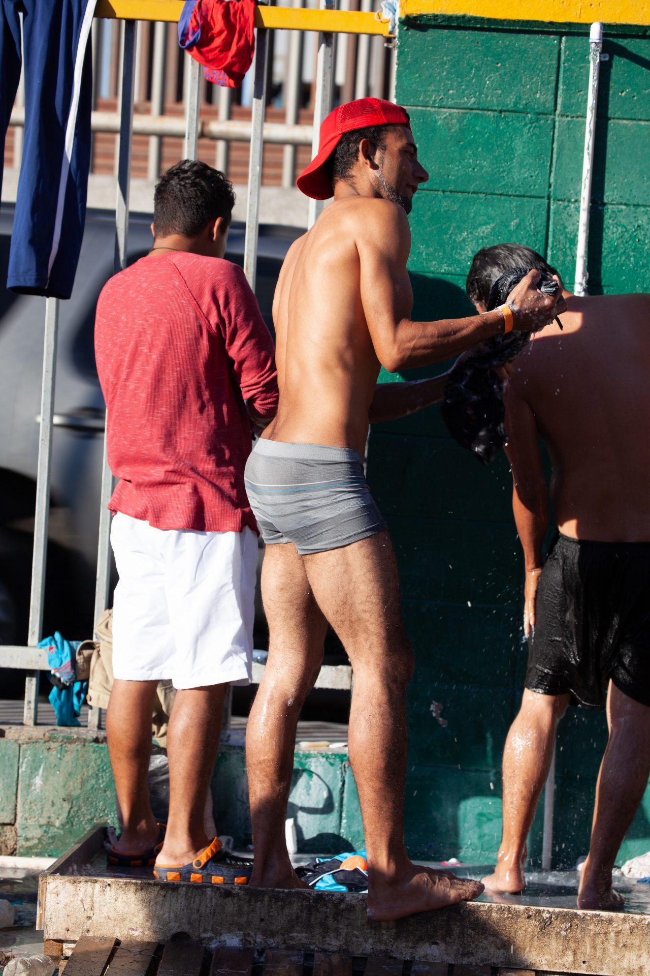 Tijuana, Baja California. Mexico. Monday, November 26th, 2018. A group of refugee men taking a shower at Unidad Deportiva Benito Juárez (an improvised shelter for the caravans of immigrants). They are fleeing violence and extreme poverty in their countries in Central America. They want to apply for asylum in the United States of America. Credit: Photo by LoveIsAmor.com