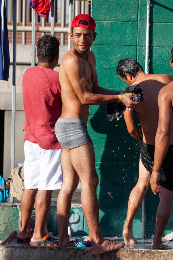Tijuana, Baja California. Mexico. Monday, November 26th, 2018. A group of refugee men taking a shower at Unidad Deportiva Benito Juárez (an improvised shelter for the caravans of immigrants). They are fleeing violence and extreme poverty in their countries in Central America. They want to apply for asylum in the United States of America. Credit: Photo by LoveIsAmor.com