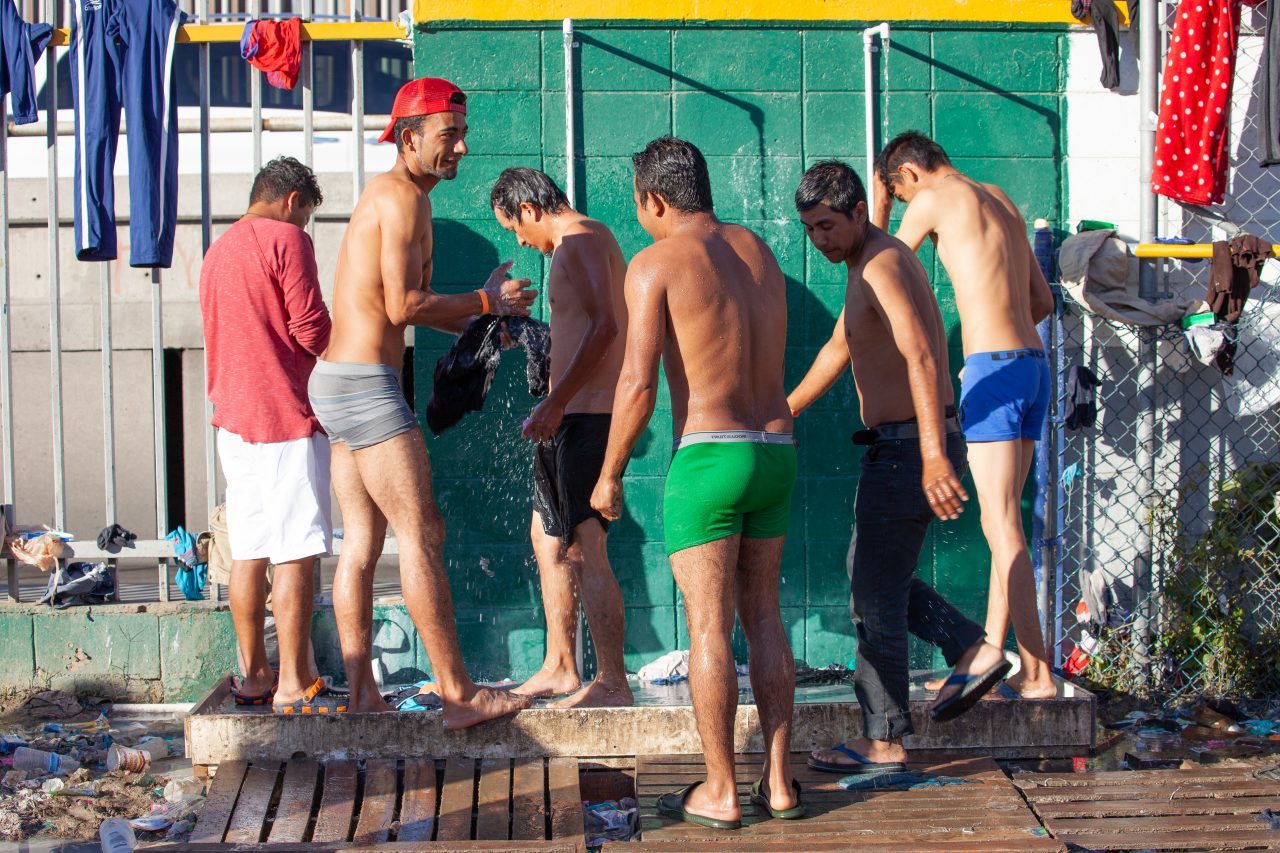 Tijuana, Baja California. Mexico. Monday, November 26th, 2018. A group of refugee men taking a shower at Unidad Deportiva Benito Juárez (an improvised shelter for the caravans of immigrants). They are fleeing violence and extreme poverty in their countries in Central America. They want to apply for asylum in the United States of America. Credit: Photo by LoveIsAmor.com
