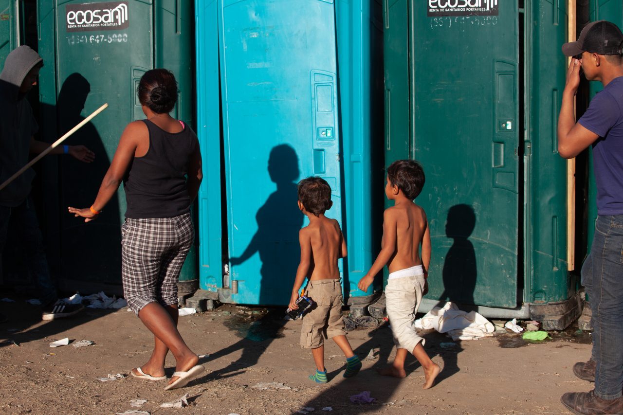 Tijuana, Baja California. Mexico. Monday, November 26th, 2018. A family of refugee looking for a bathroom at Unidad Deportiva Benito Juárez (an improvised shelter for the caravans of immigrants). Bathrooms are located inside the makeshift shelter. Bathrooms smell really bad and are already at their maximum capacity. Authorities need to change the portable toilets. This is not healthy for refugees, volunteers, media and others. Immigrants are fleeing violence and extreme poverty in their countries in Central America. They want to apply for asylum in the United States of America. Credit: Photo by LoveIsAmor.com