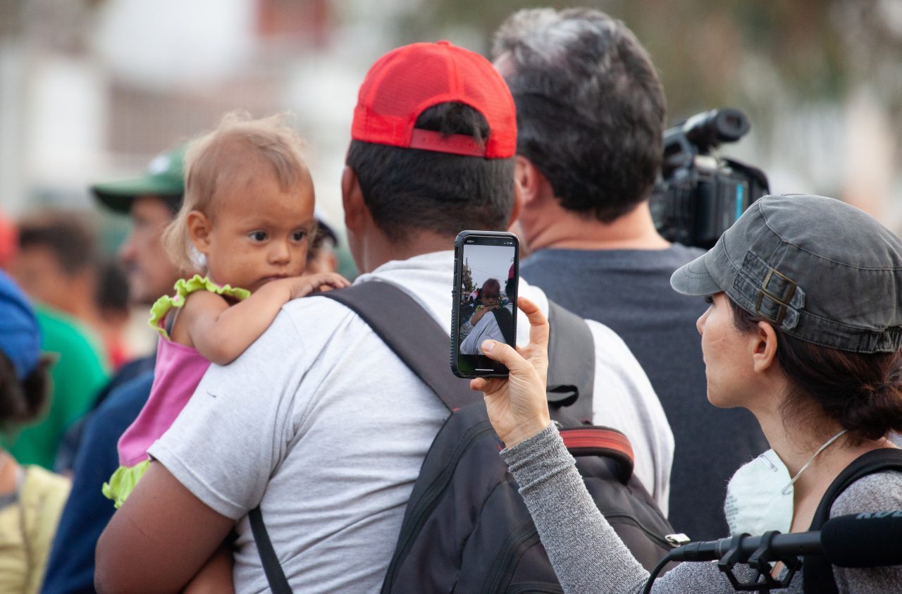 Tijuana, Baja California. Mexico. Tuesday, November 27th, 2018. Woman filming a refugee girl and her parents arriving from Mexicali, Baja California. Mexico. Refugees are going to stay at Unidad Deportiva Benito Juárez (an improvised shelter for the caravans of immigrants). Refugees are fleeing violence in their countries in Central America. They want to apply for asylum in the United States of America. Credit: Photo by LoveIsAmor.com