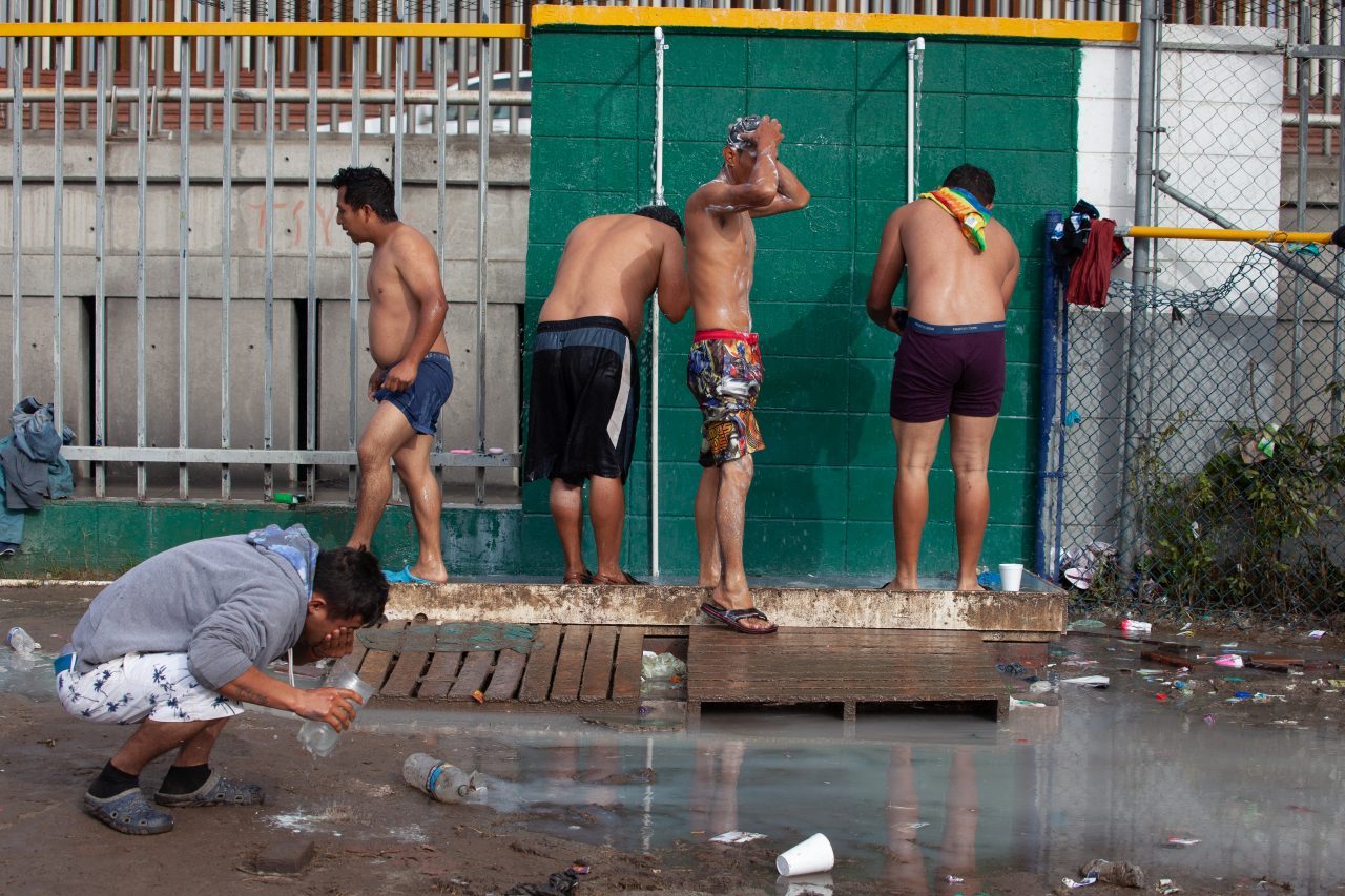 Tijuana, Baja California. Mexico. Thursday, November 29th, 2018. Refugee men taking a shower at Unidad Deportiva Benito Juárez (an improvised shelter for the caravans of immigrants). Refugees are fleeing violence and extreme poverty in their countries in Central America. They want to apply for asylum in the United States of America. They were told they have to wait more than a month to apply for asylum. Credit: Photo by LoveIsAmor.com