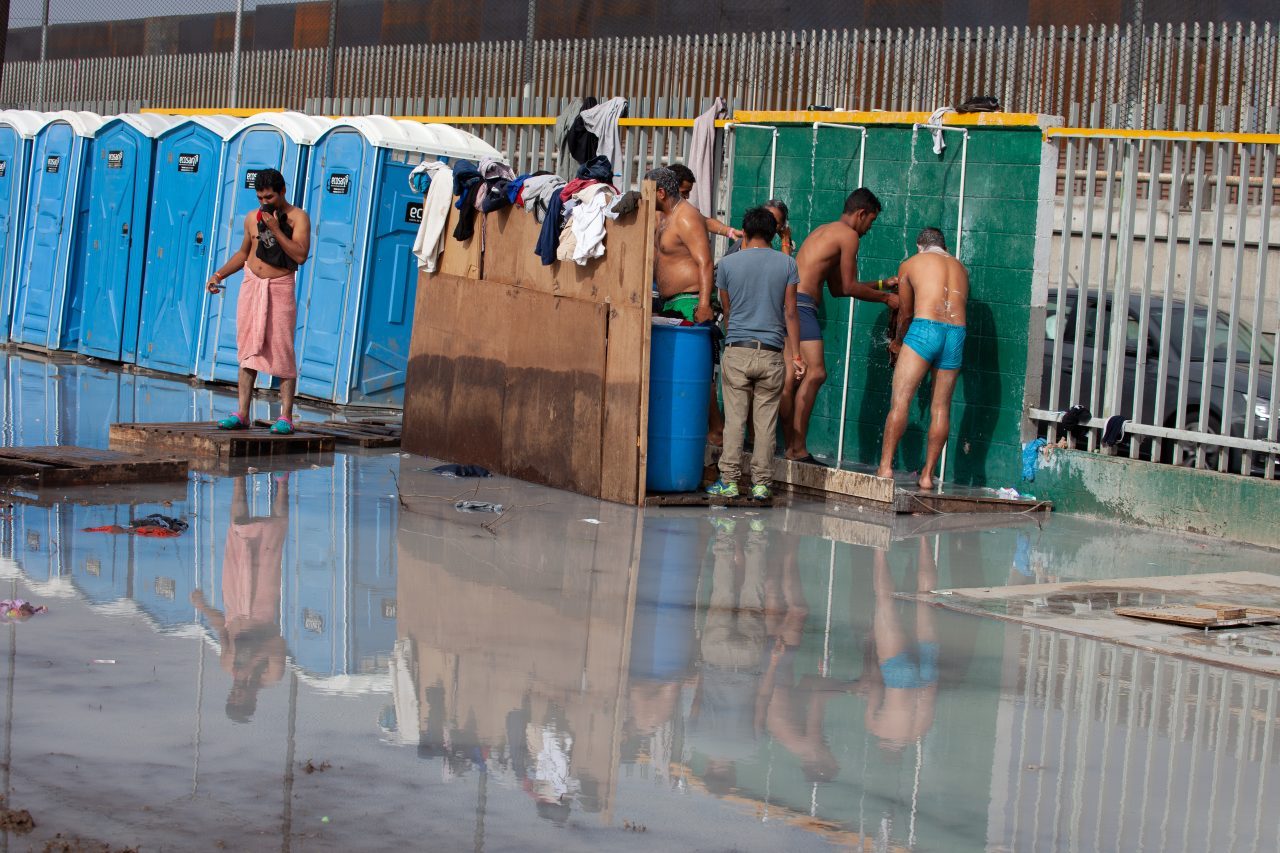 Tijuana, Baja California. Mexico. Thursday, November 29th, 2018. Refugee men taking a shower at Unidad Deportiva Benito Juárez (an improvised shelter for the caravans of immigrants). Refugees are fleeing violence and extreme poverty in their countries in Central America. They want to apply for asylum in the United States of America. They were told they have to wait more than a month to apply for asylum. Credit: Photo by LoveIsAmor.com